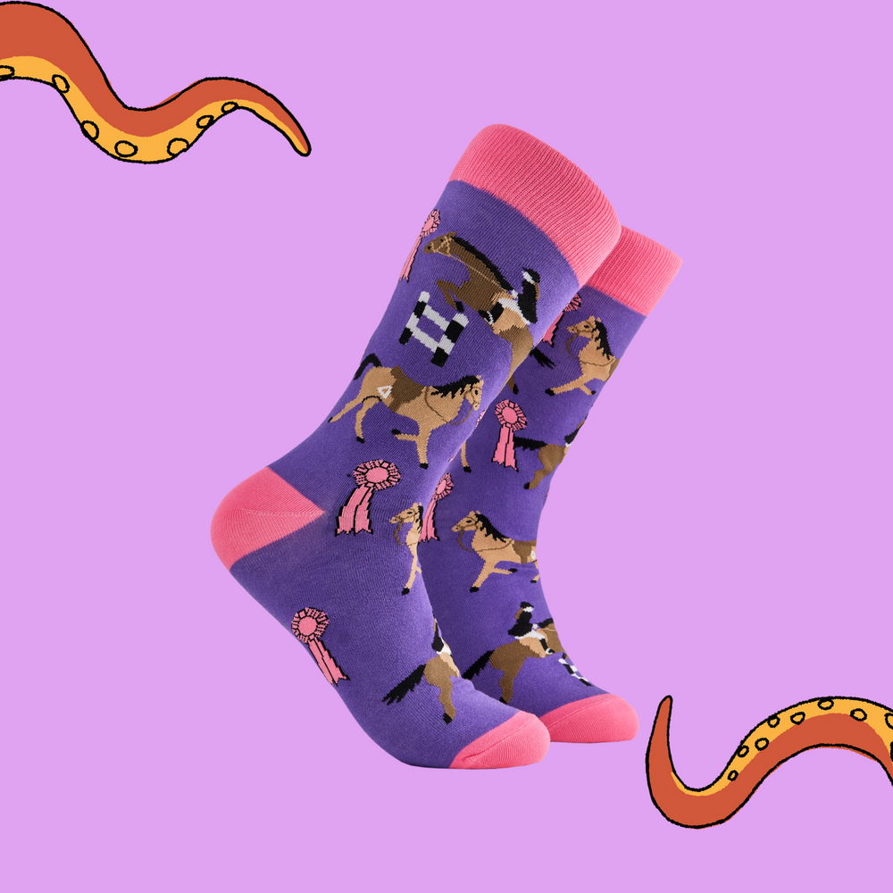 A pair of socks depicting tea cups and show jumping horses. Purple legs, pink cuff, heel and toe.