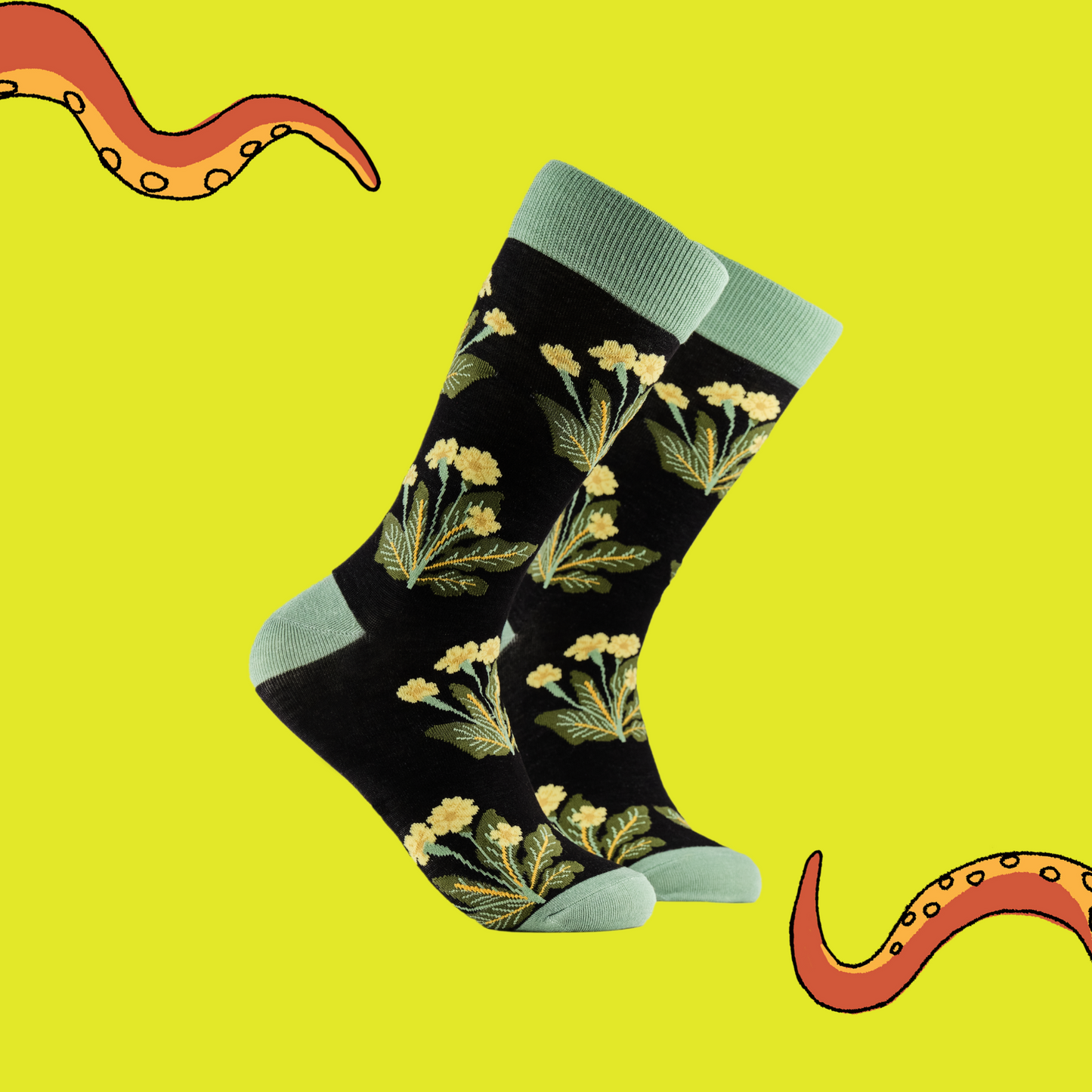 A pair of socks depicting primroses. Black legs, green cuff, heel and toe.
