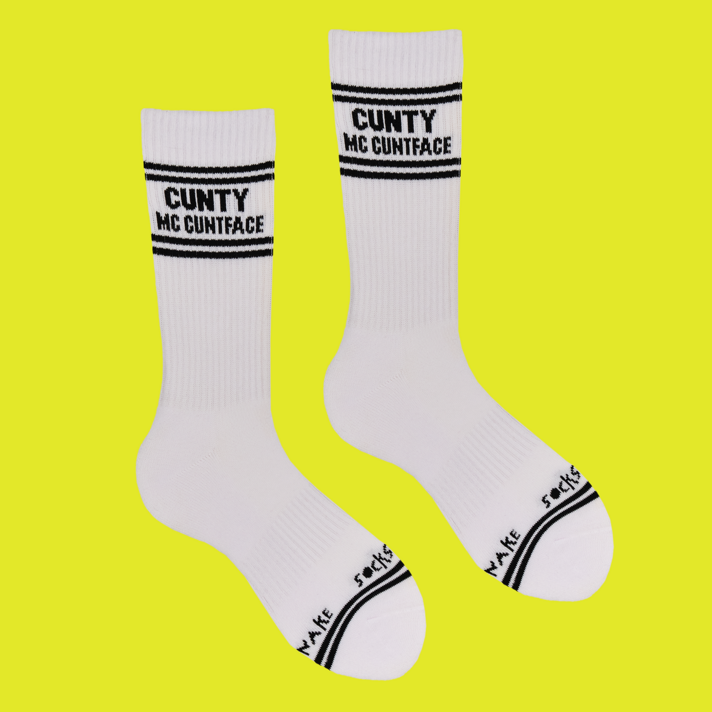A white pair of athletic socks with black trim on the ankles and toes. With some very rude words on the ankle.