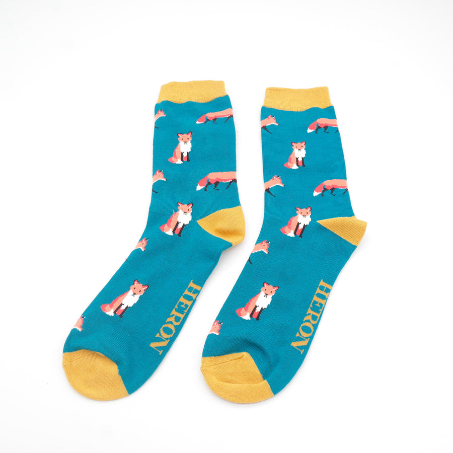 
                  
                    A pair of socks featuring a cute fox design. Teal legs, yellow cuff, heel and toe.
                  
                