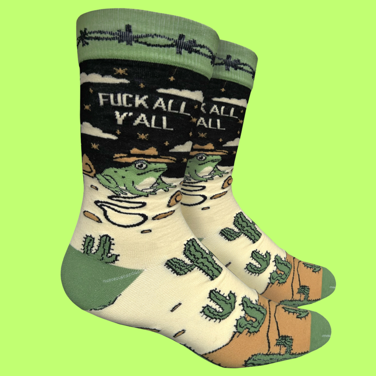 
                  
                    A pair of socks with a frog and desert motif with the slogan F**k All Y'All on the ankle. Green toes, cuff and heel.
                  
                