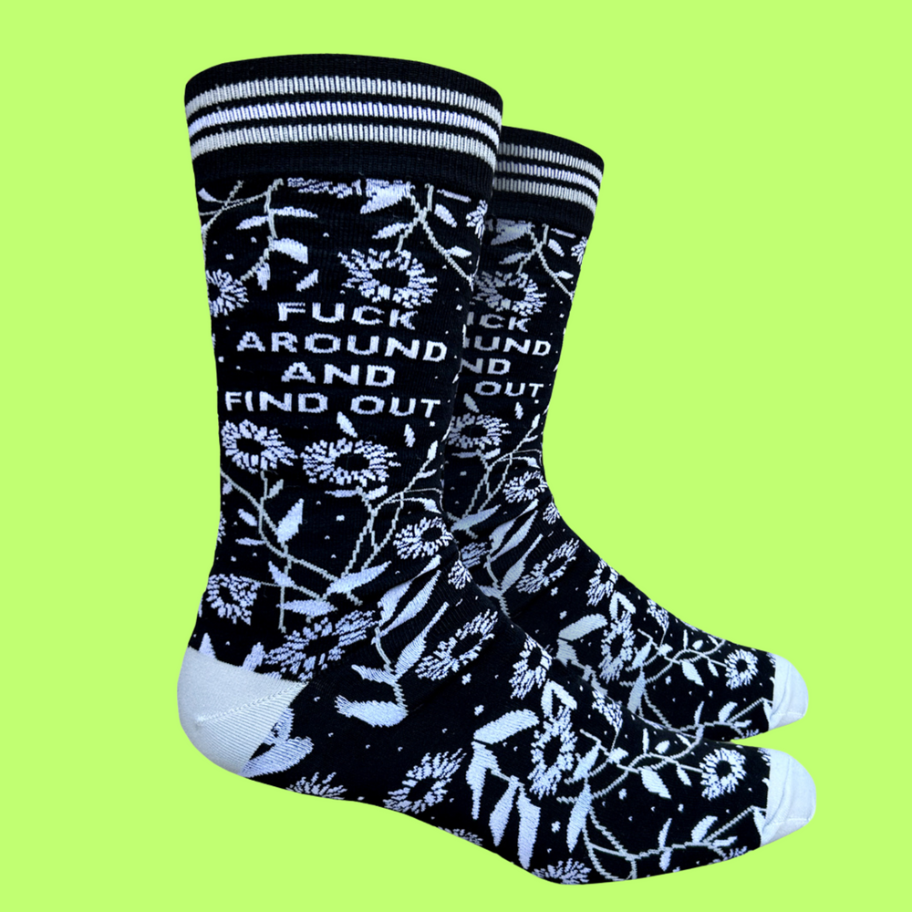 A pair of bold floral and slogan socks with black legs and light blue toes, cuff and heel.