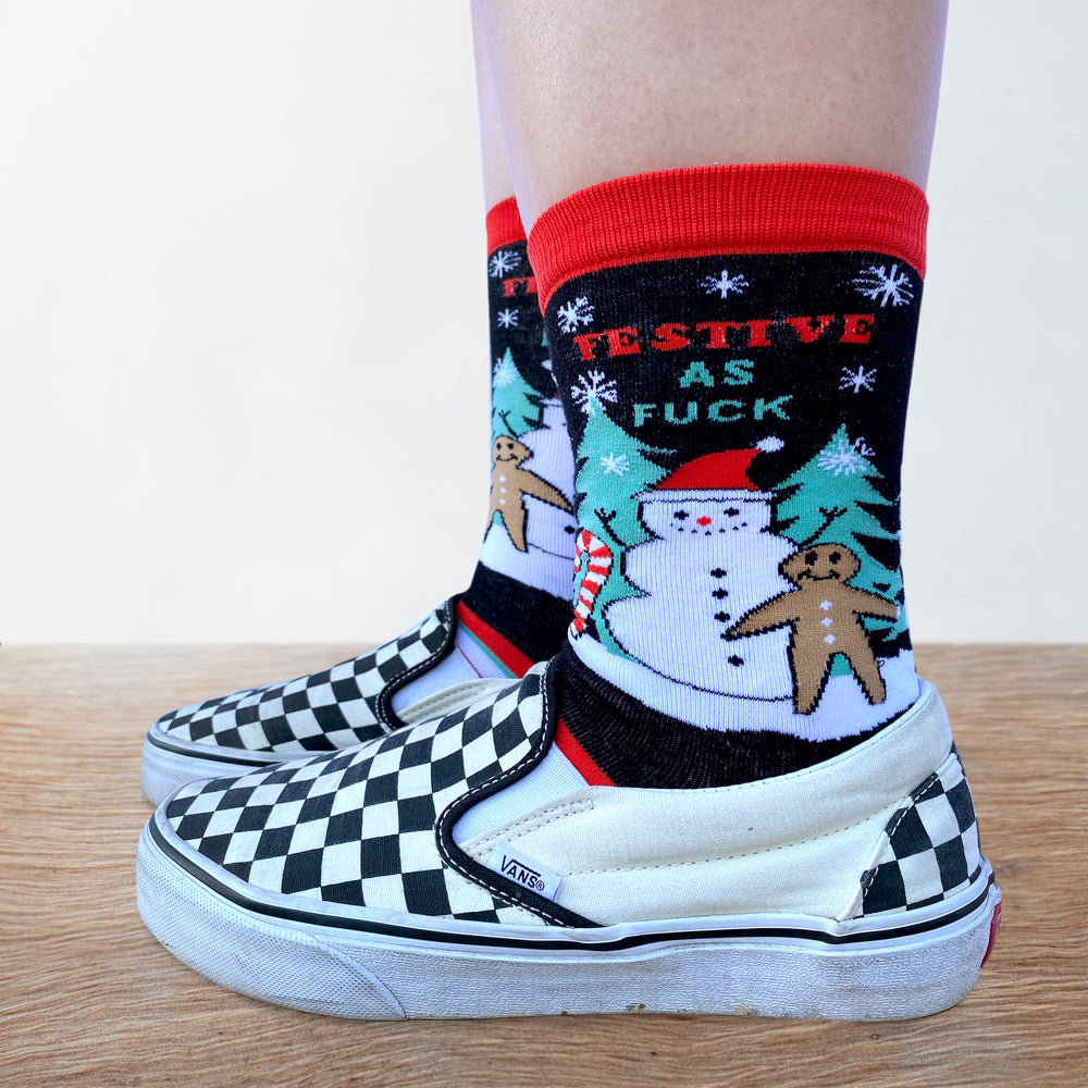 
                      
                        A pair of socks depicting with a sweary slogan and a christmas motif. Striped legs. Red toe, heel and cuff. 
                      
                    