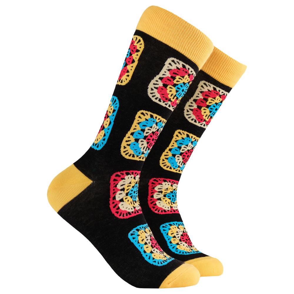 Crochet Socks - Granny Squares. A pair of socks with a multicoloured crochet motif. Black legs, yellow heel, toe and cuff. 