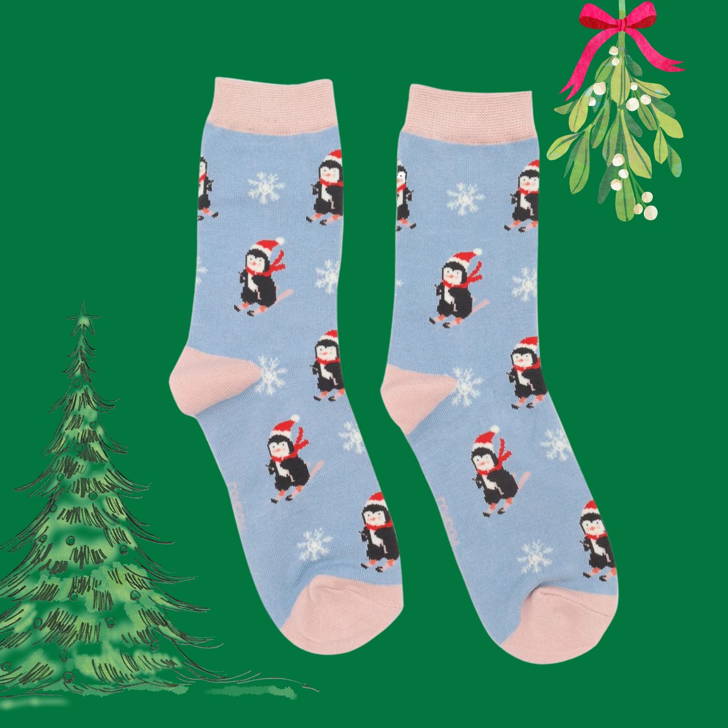 A pair of socks depicting skiing penguins and a snowflake pattern. Blu legs. Pink heel toe and cuff. 