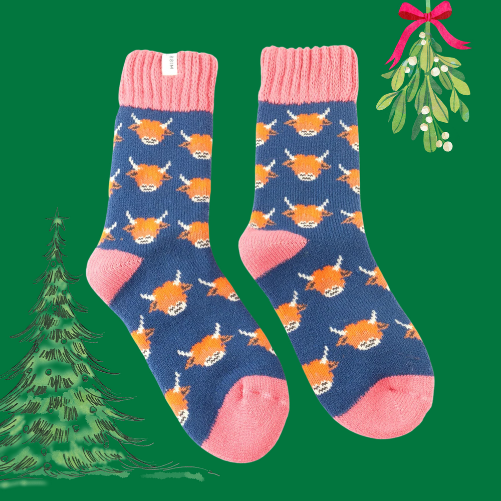 A pair of socks depicting highland cows. blue legs, pink heel, toe and cuff. 