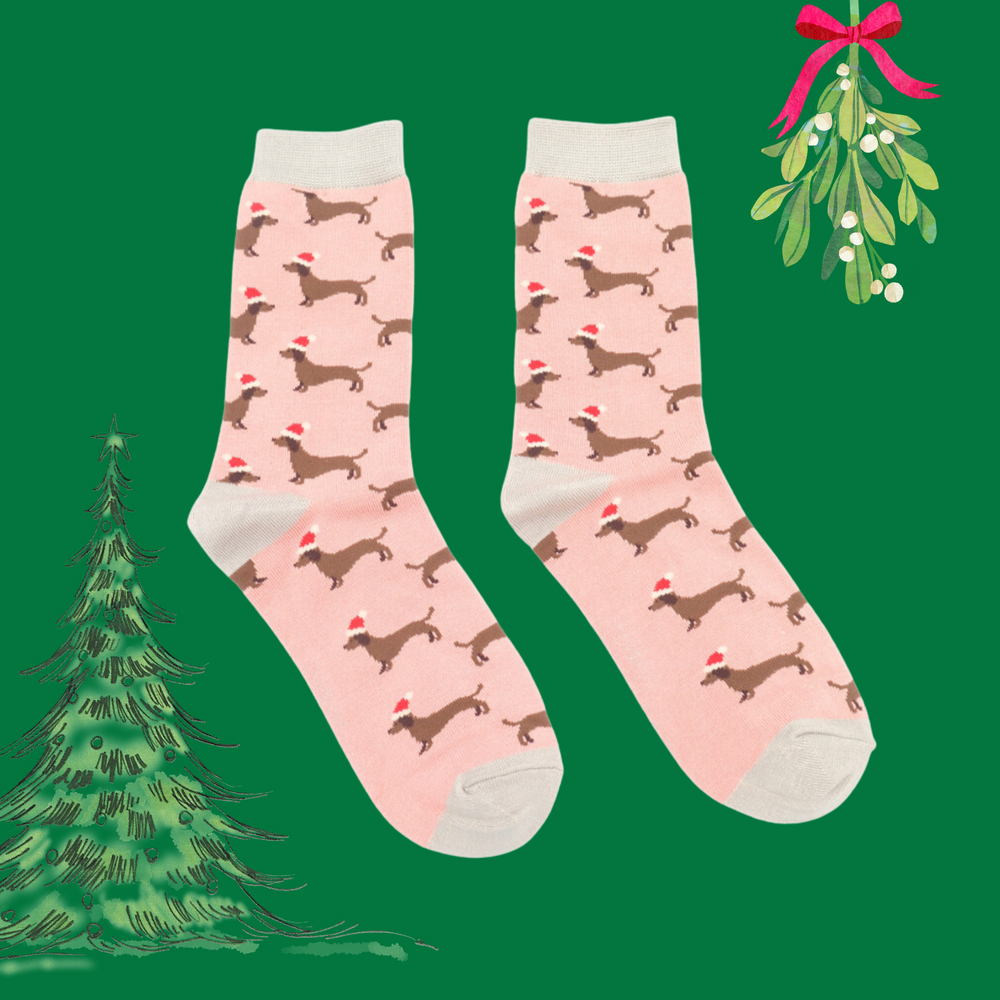 
                      
                        A pair of socks depicting sausage dogs wearing santa hats. Pink legs. Grey heel, toe and cuff. 
                      
                    