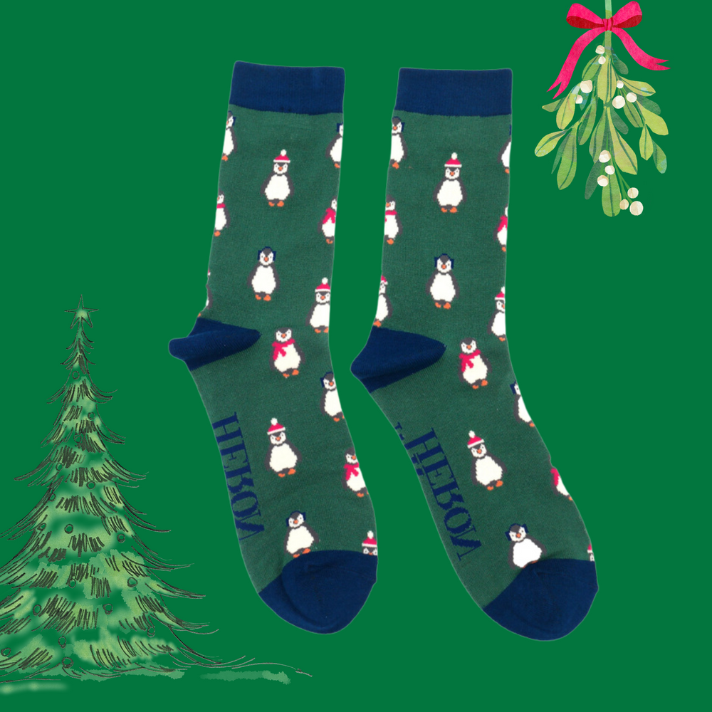 
                      
                        A pair of socks depicting penguins wearing hats and scarves for the winter. Green legs, blue toes, heels and cuffs. 
                      
                    