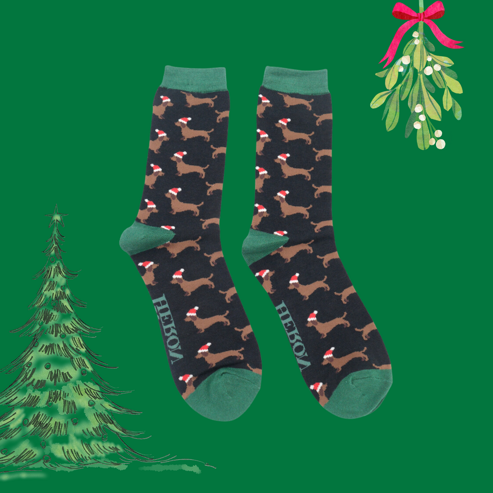 
                      
                        A pair of socks depicting sausage dogs wearing santa hats. Black legs. Green heel, toe and cuff. 
                      
                    