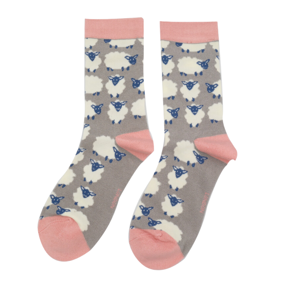 A pair of socks depicting happy sheep. Grey legs, pink heel, toe and cuff.