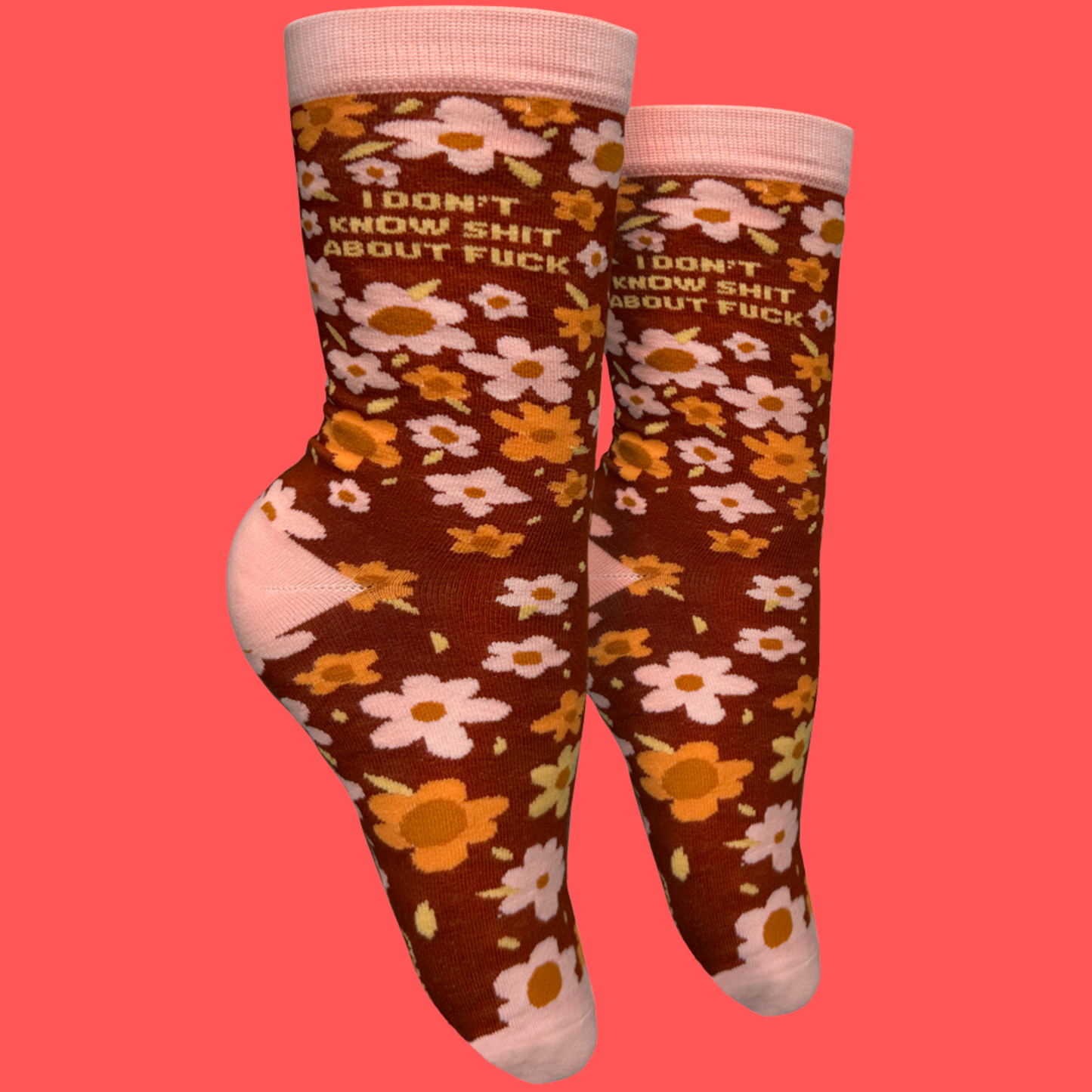 
                  
                    A pair of socks with a bold sweary slogan and a bold flowers design. Pink toes, hell and cuff.
                  
                