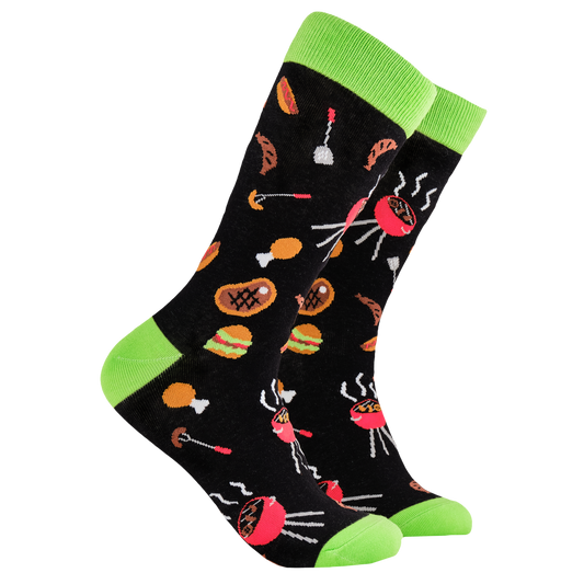 BBQ Socks - King of The Grill. A pair of socks depicting Meat and BBq tools. Black legs, green cuff, heel and toe.