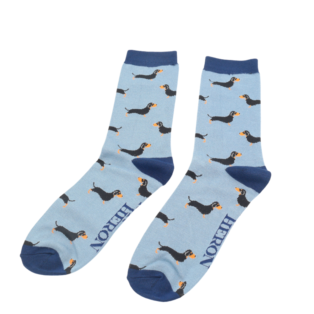 A pair of socks featuring a sausage dog pattern. Blue legs, dark blue cuffs, heel and toe.