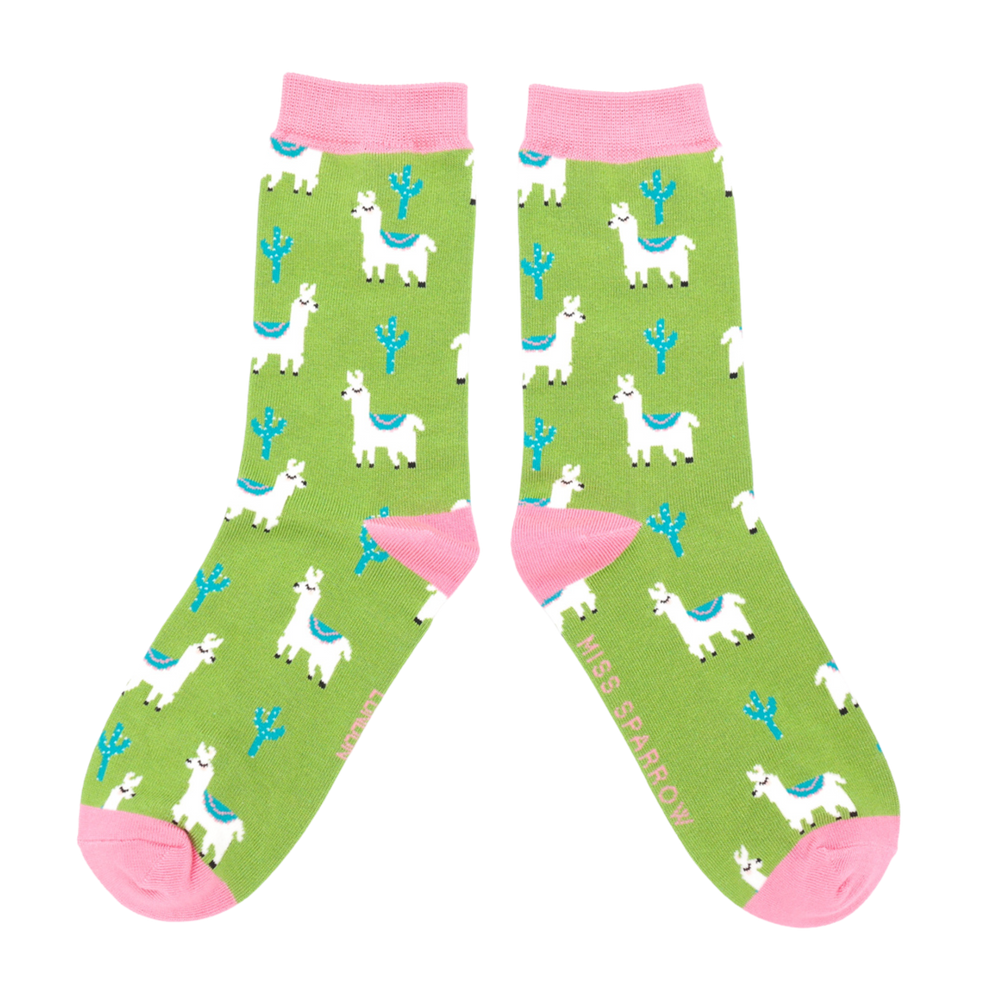 A pair of socks depicting cacti and Llamas. Green legs, pink cuff, heel and toe.