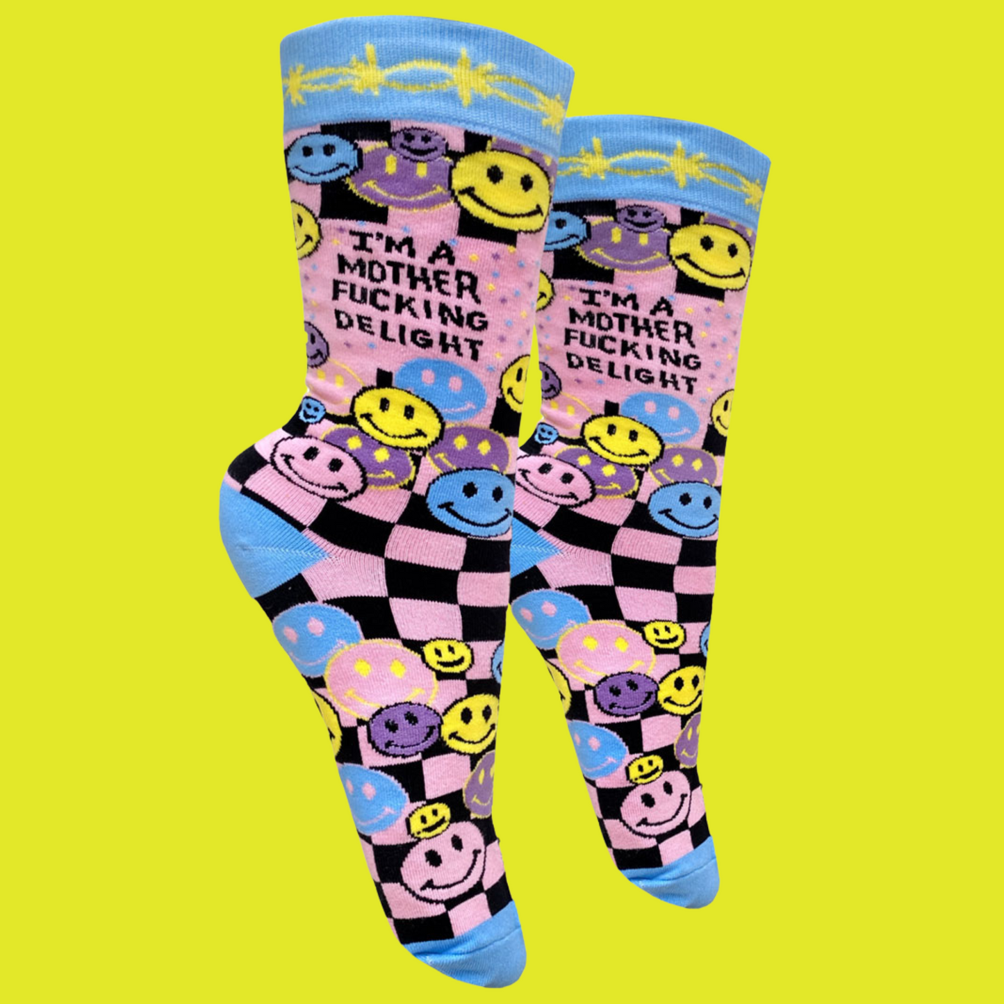 A pair of socks with a bright pink and blue smiley face pattern and a bold sweary slogan. Blue toes, heel and cuff.