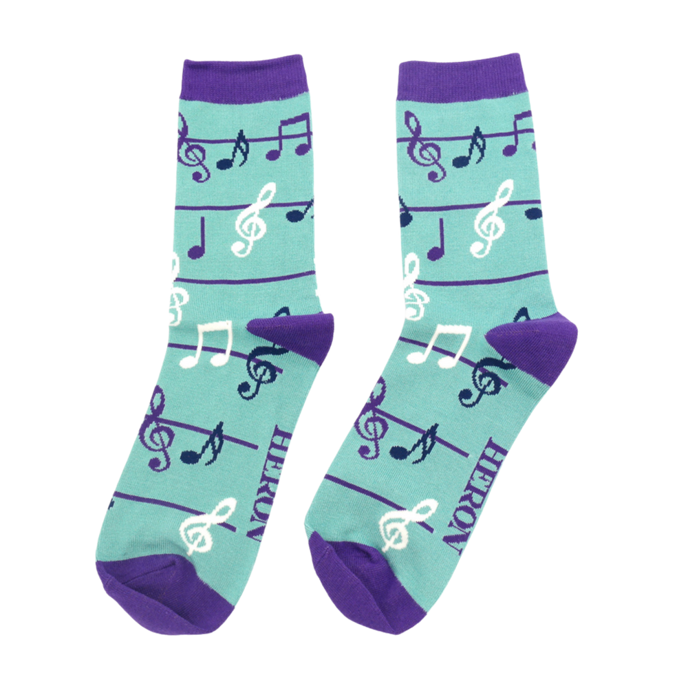 A pair of socks with a music note pattern. Dark Blue legs, purple cuffs, heel and toe.