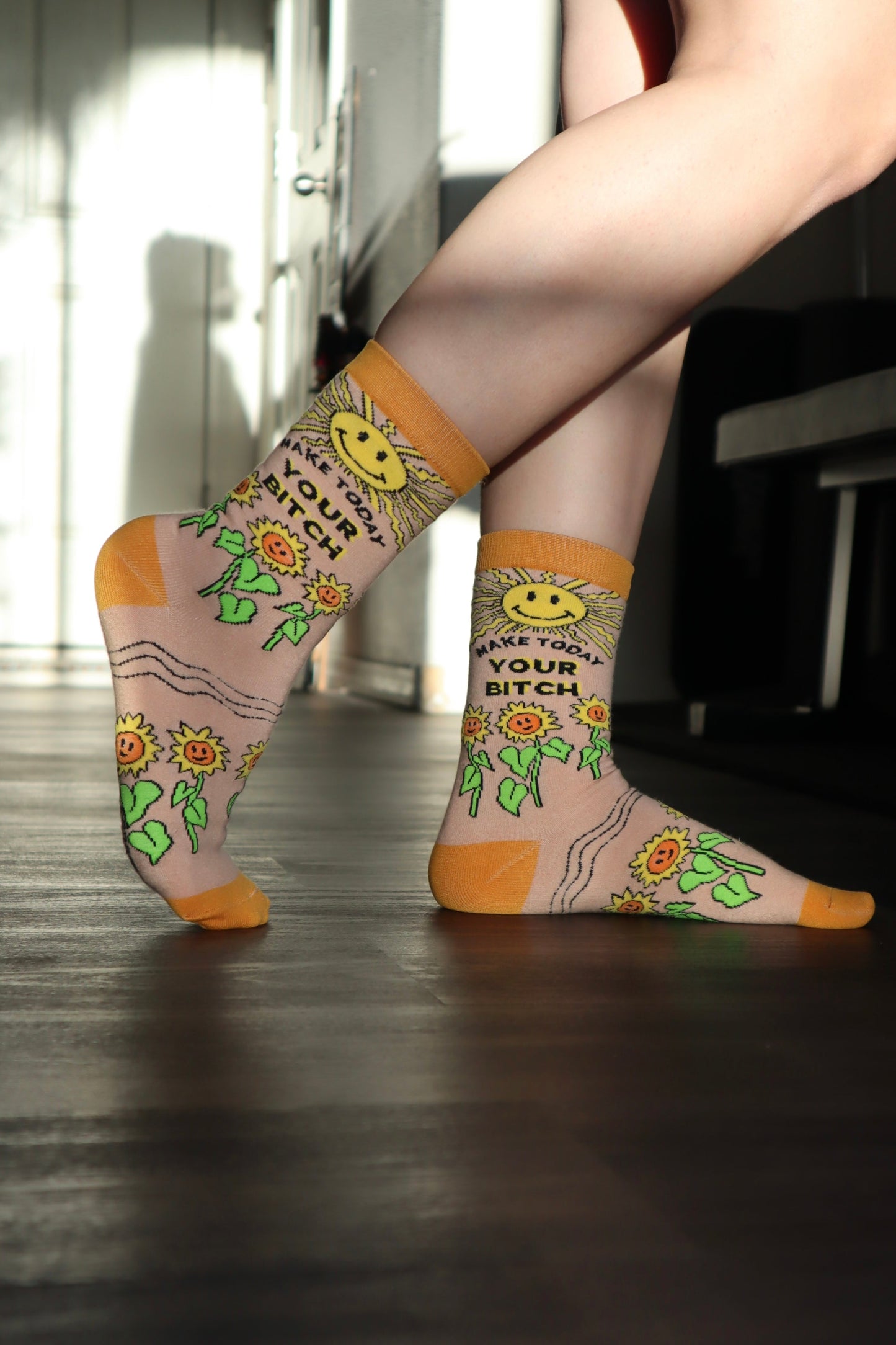 
                  
                    Make Today Your B**tch Socks. A pair of socks depicting the sun and sunflowers with a bold sweary slogan. Orange toes, cuff and heel.
                  
                