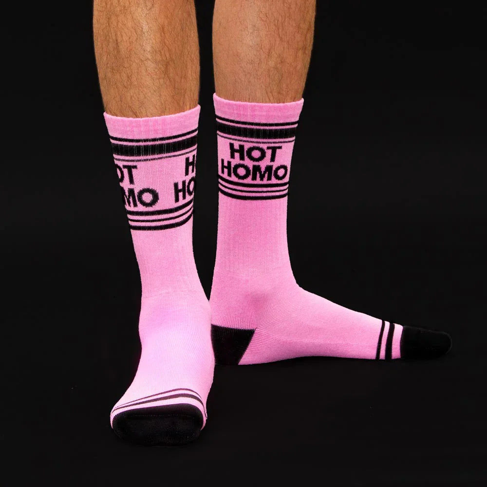 
                      
                        A bright pink pair of sports style socks with the slogan "Hot Homo". 
                      
                    