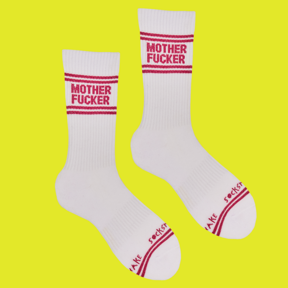 A white pair of athletic socks with red trim on the ankles and toes. With a very rude insult involving mothers on the ankle.