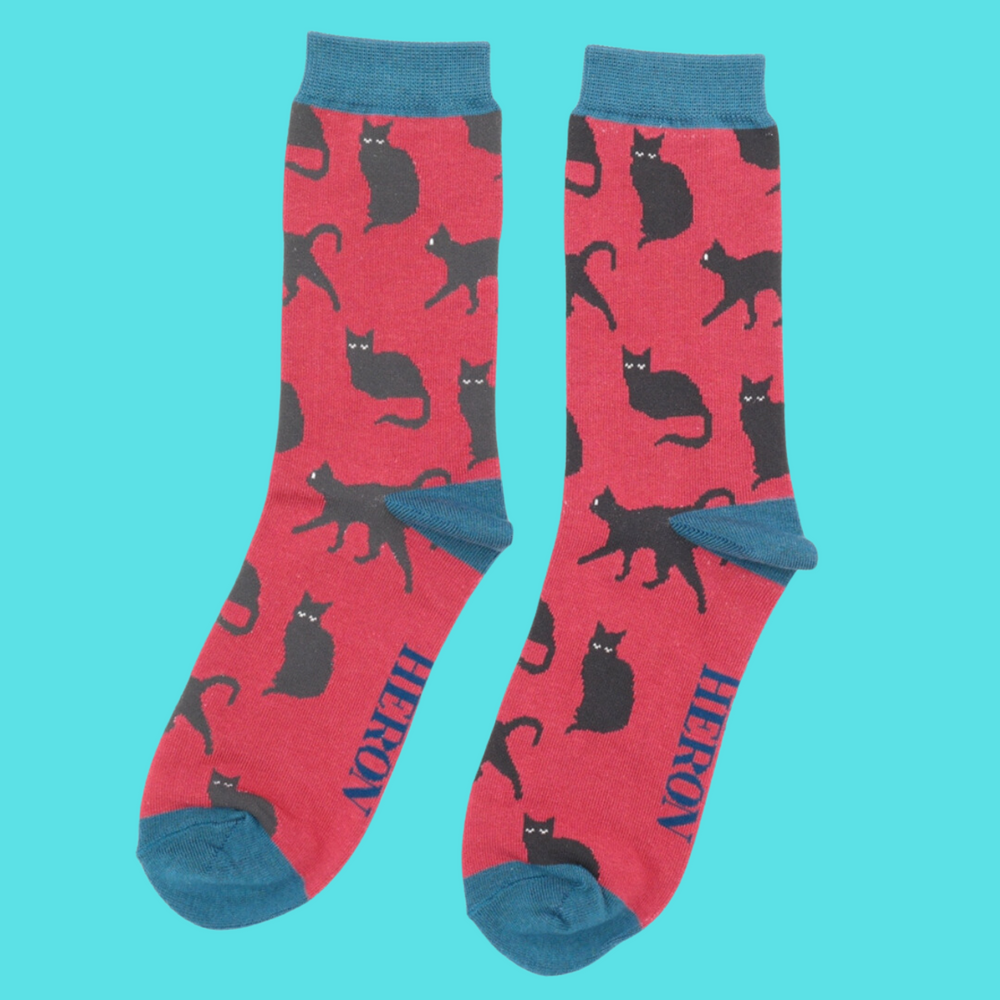 
                  
                    A pair of socks depicting cute black cats. Red legs, blue toe, cuff and heel.
                  
                