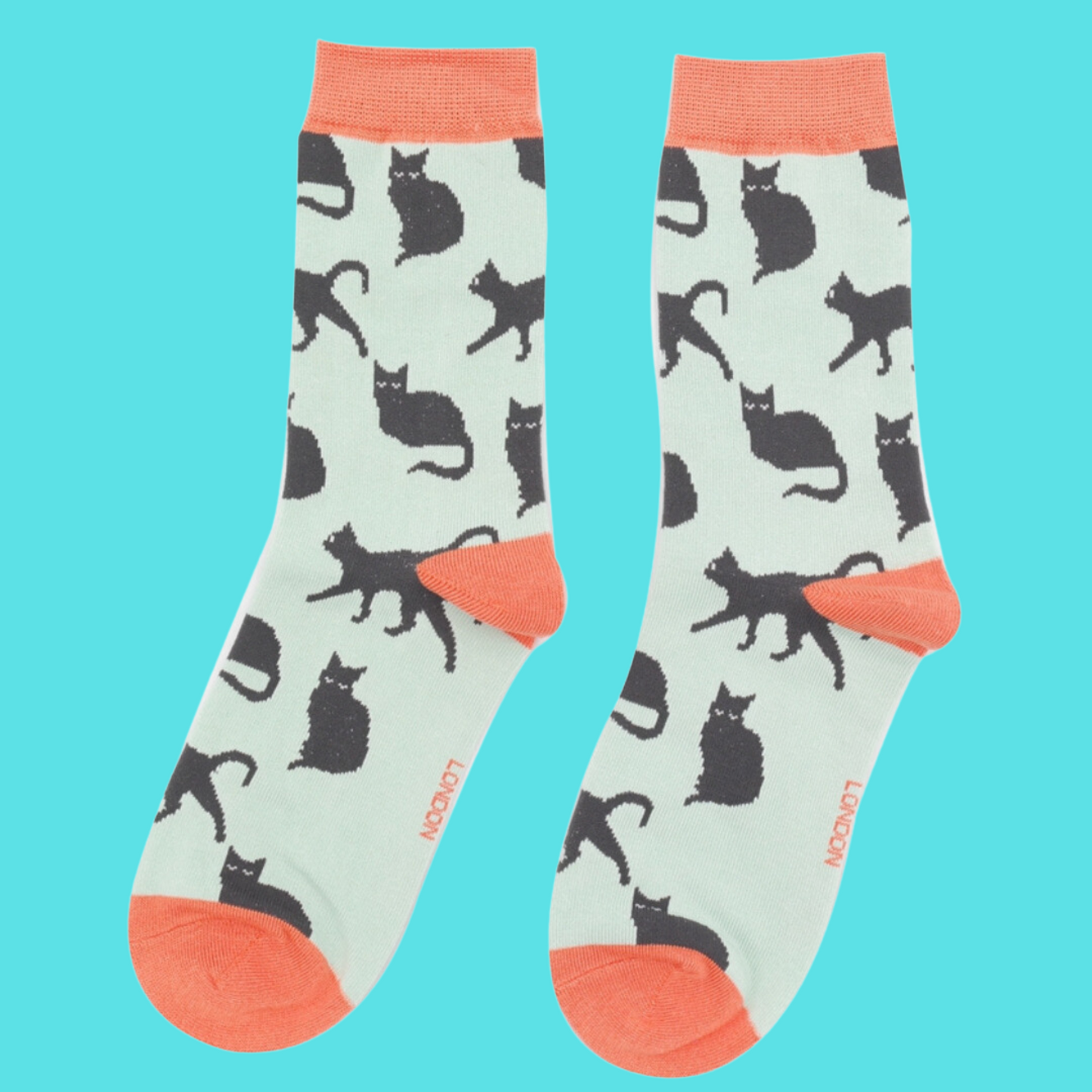 
                  
                    A pair of socks depicting cute black cats. Green legs, peach toe, cuff and heel.
                  
                