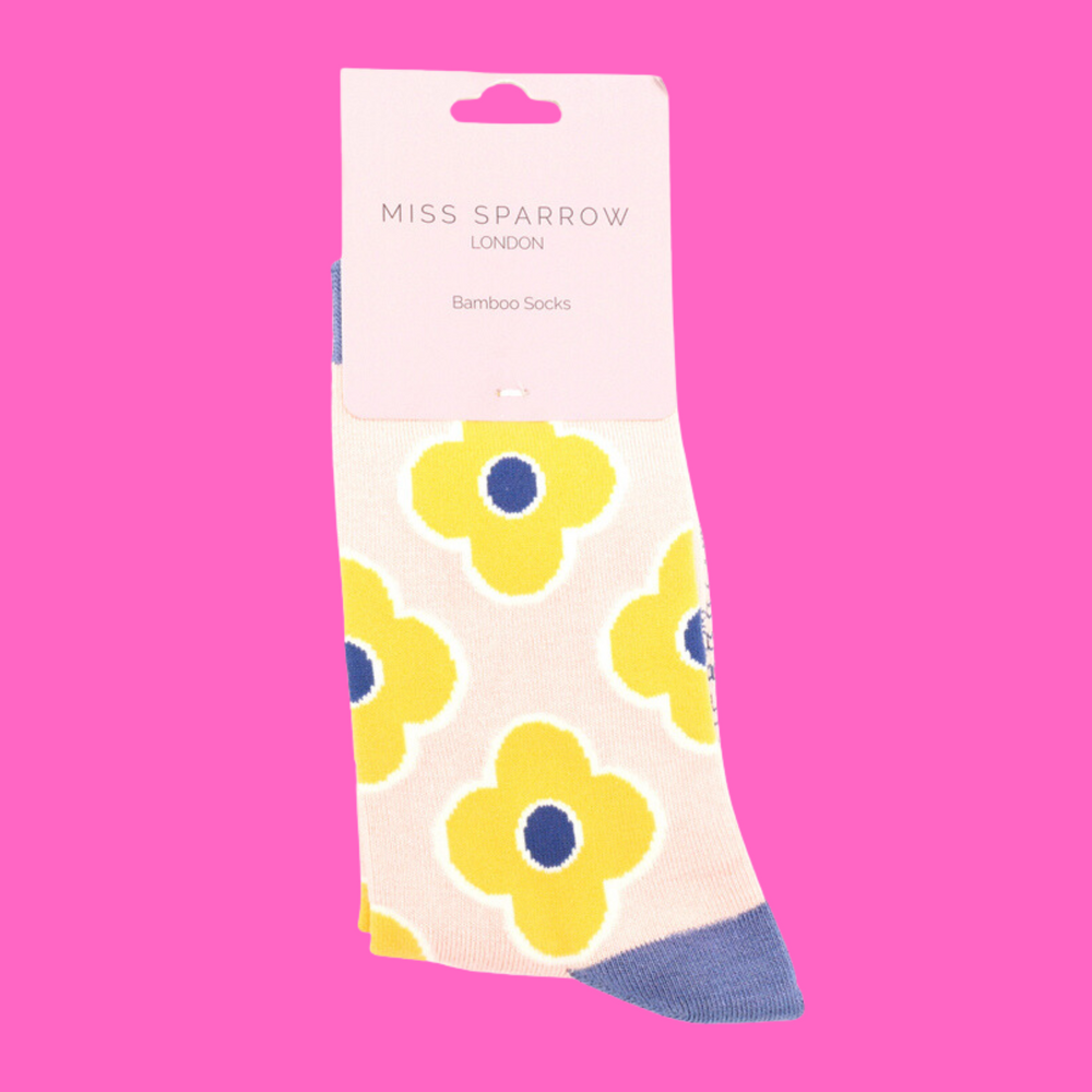 
                      
                        A pair of socks depicting a retro flower pattern. Cream legs, light blue heel, toe and cuff.
                      
                    