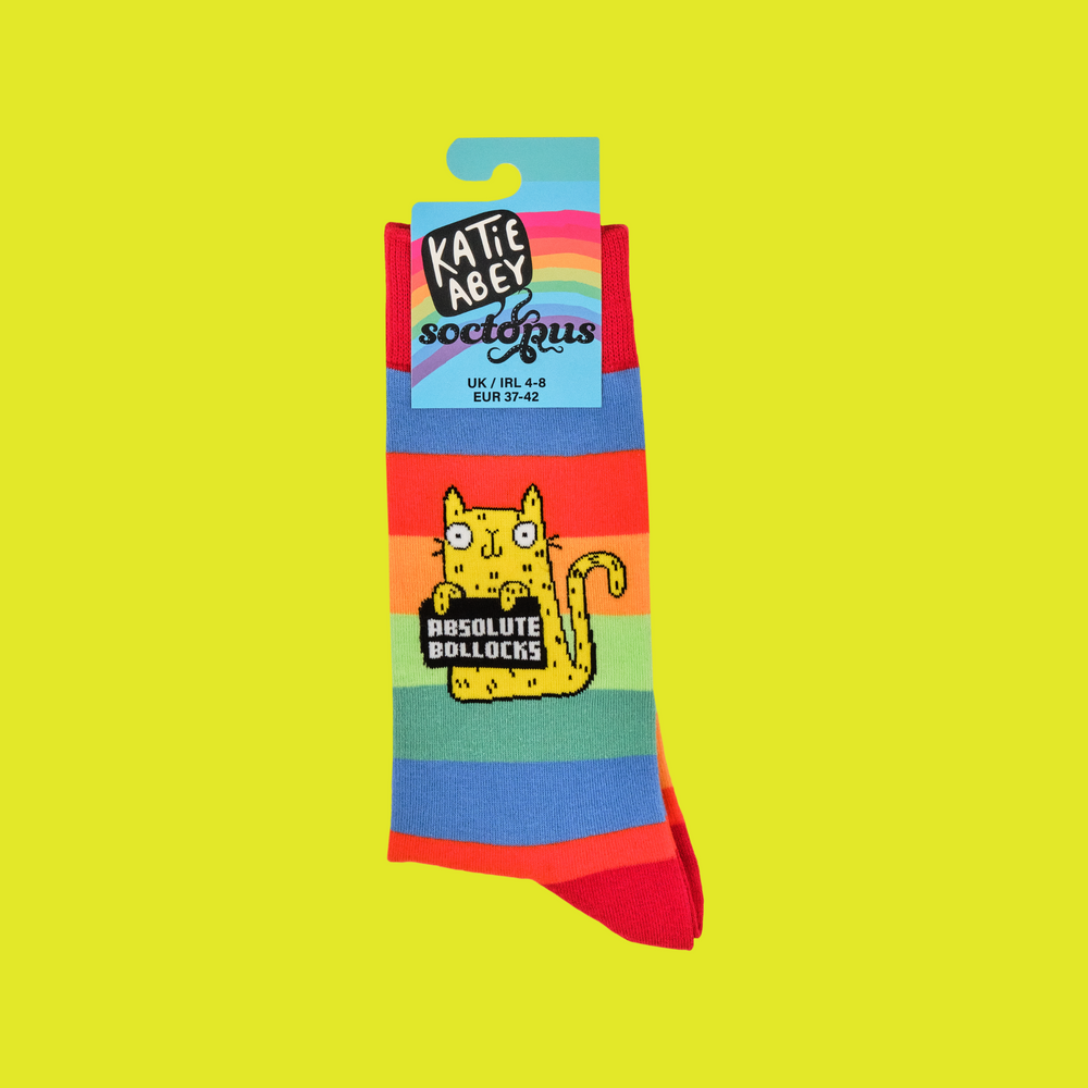 
                      
                        A pair of socks depicting a cute cat holding a sweary sign. Rainbow striped legs. 
                      
                    