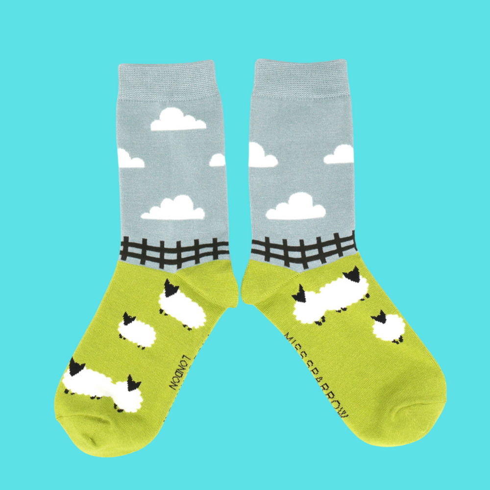 A pair of socks depicting sheep in a field.