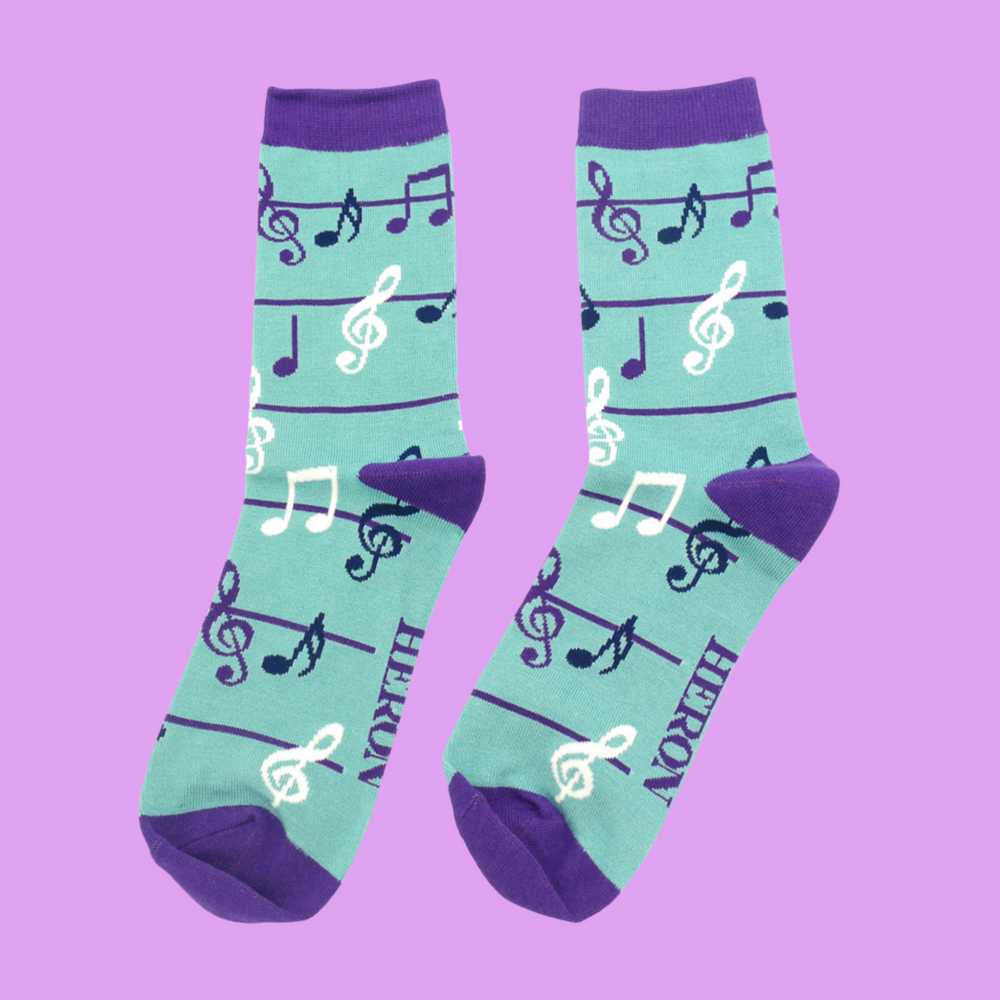 
                  
                    A pair of socks with a music note pattern. Dark Blue legs, purple cuffs, heel and toe.
                  
                