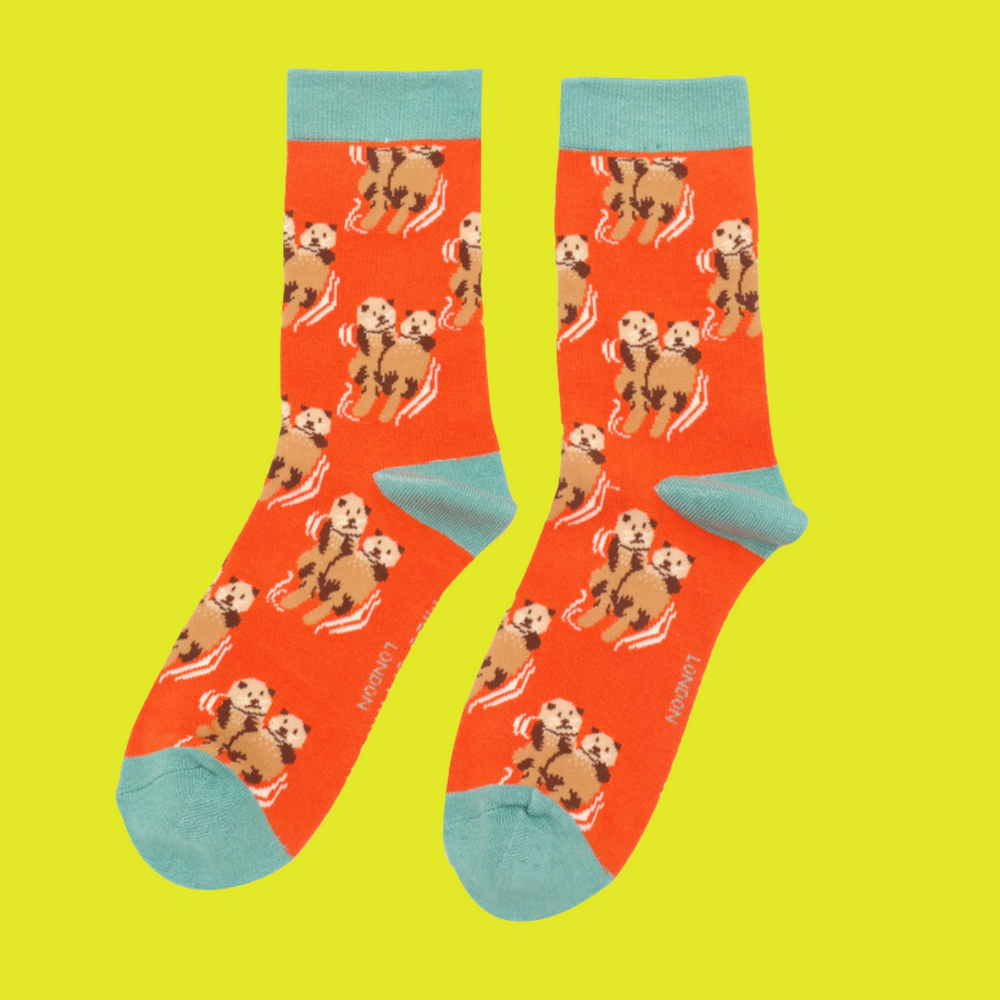 
                  
                    A pair of socks depicting otters holding hands. Orange legs, light blue heel, toe and cuff.
                  
                