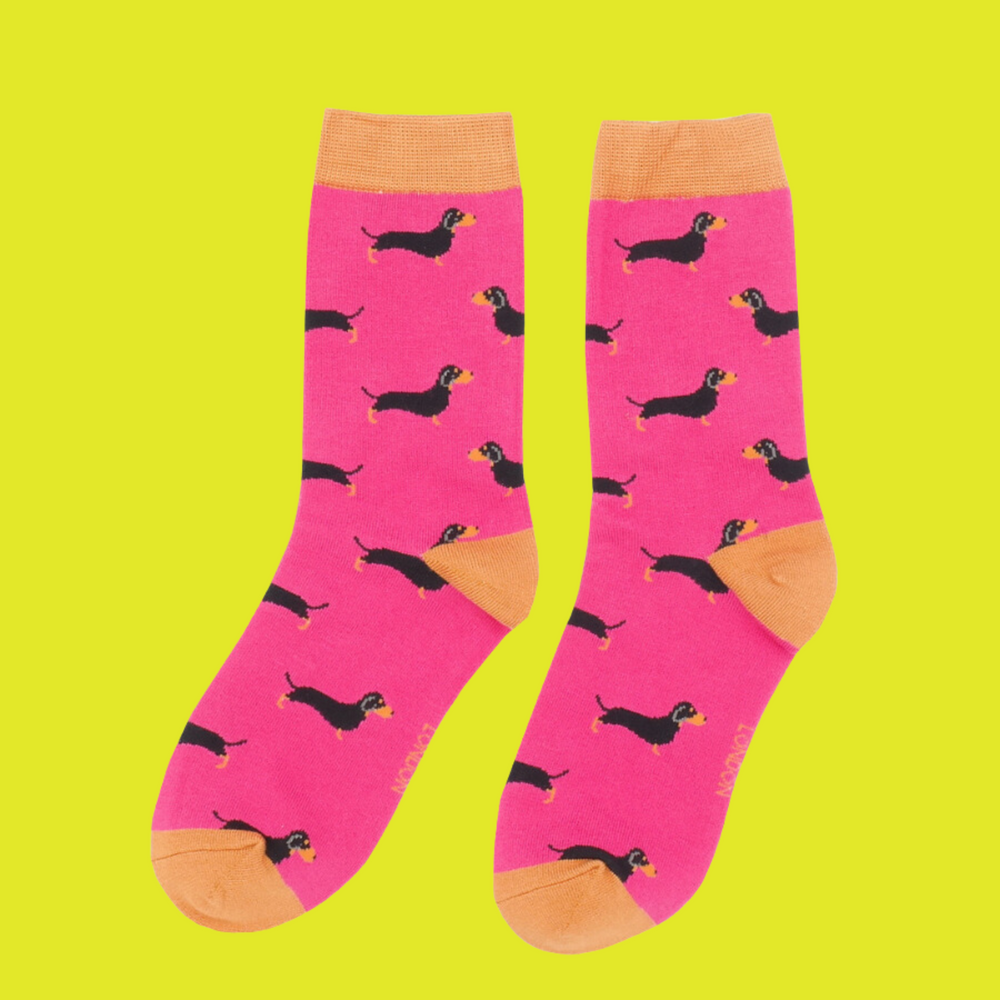 
                  
                    A pair of socks featuring a sausage dog pattern. Hot pink legs, orange cuffs, heel and toe.
                  
                