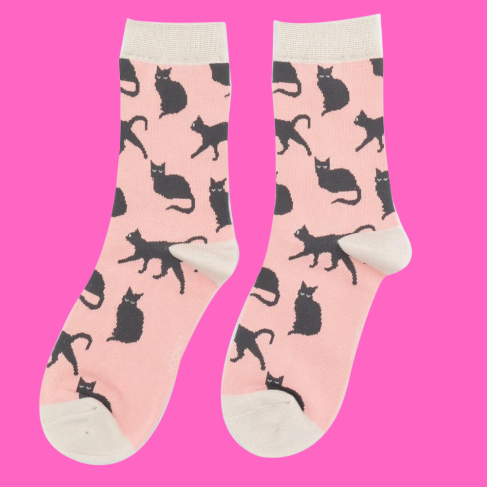 
                  
                    A pair of socks depicting cute black cats. Pink legs, cream toe, cuff and heel.
                  
                