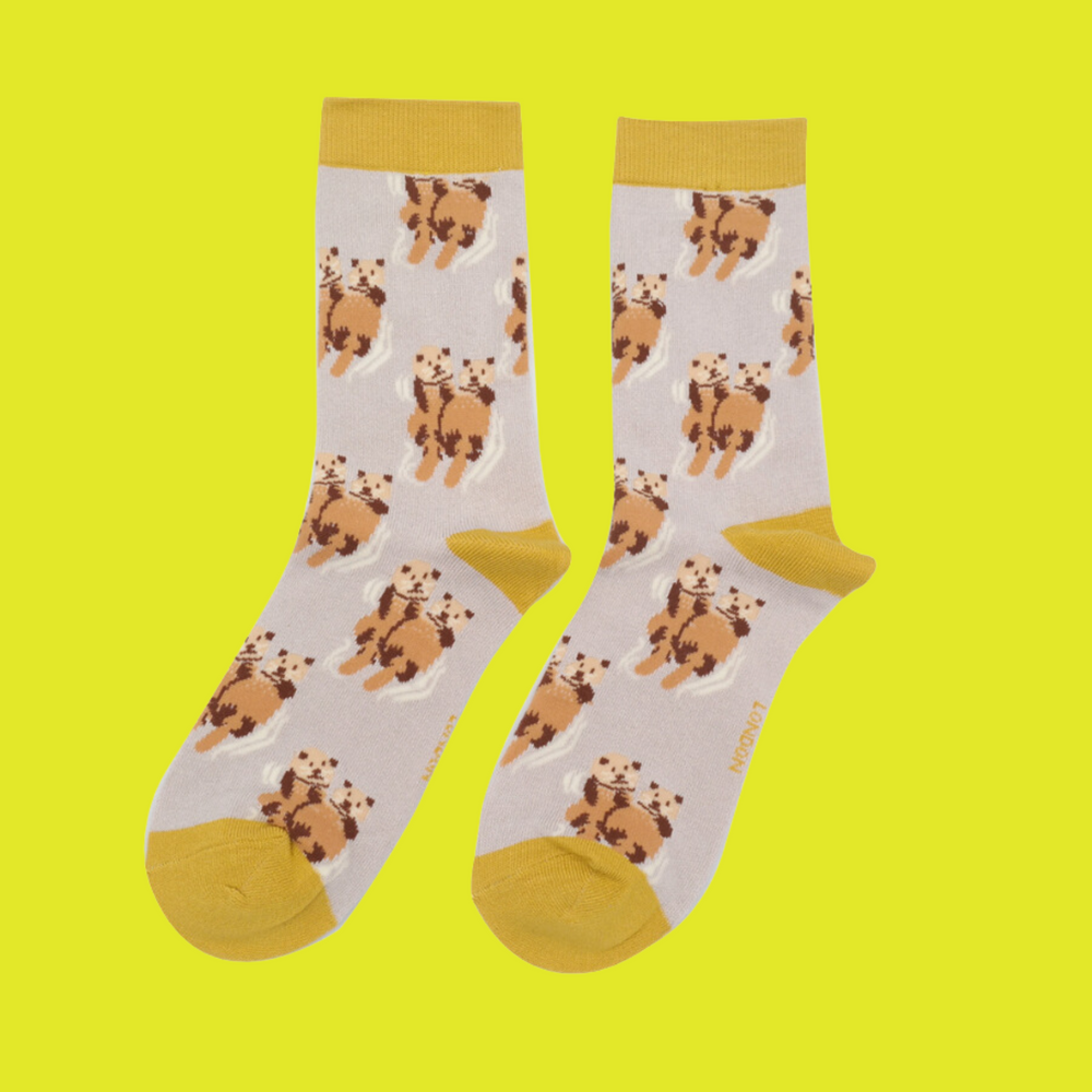 
                  
                    A pair of socks depicting otters holding hands. Cream legs, yellow heel, toe and cuff.
                  
                