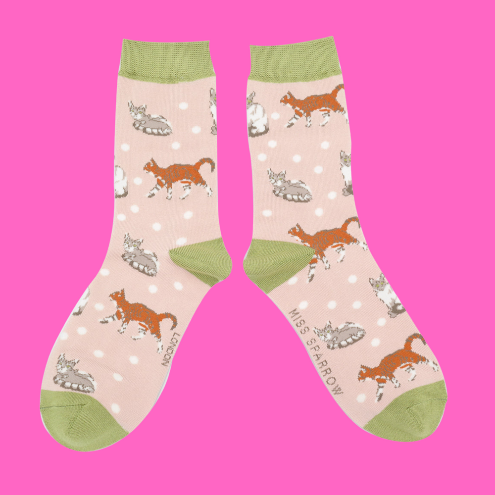 
                      
                        A pair of socks with a cat motif and spots pattern. Light pink legs, green heel, toe and cuff. 
                      
                    