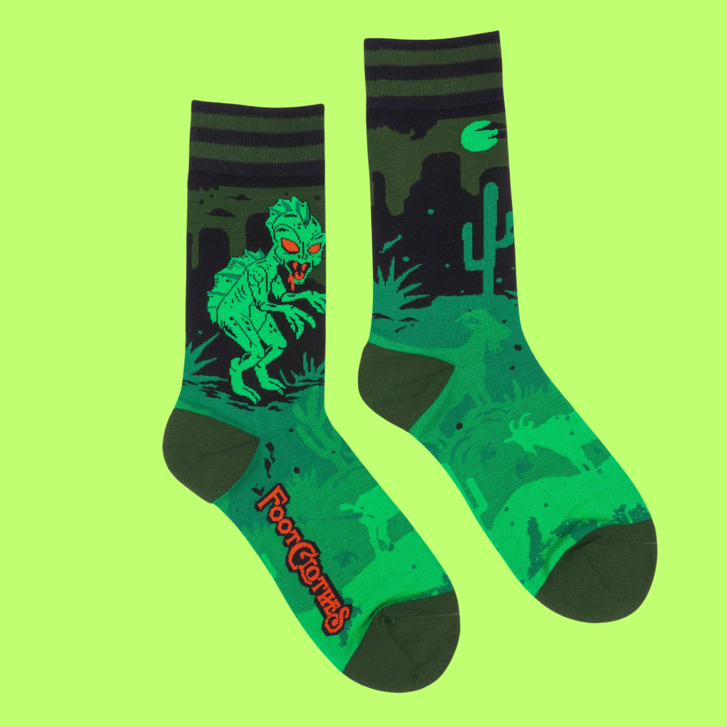 A pair of socks featuring El Chupacabra. Green legs, heel, toe and cuff. 