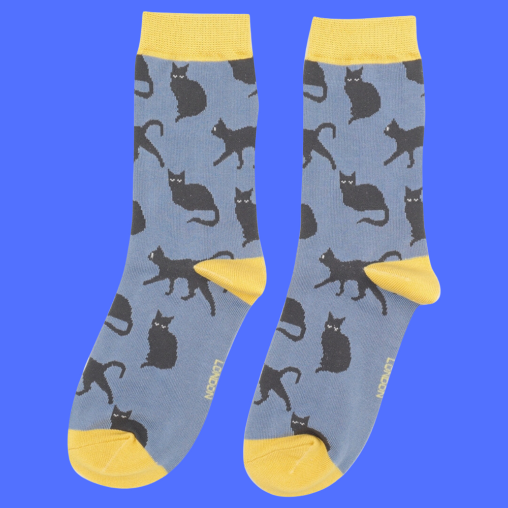 
                  
                    A pair of socks depicting cute black cats. Blue legs, yellow toe, cuff and heel.
                  
                