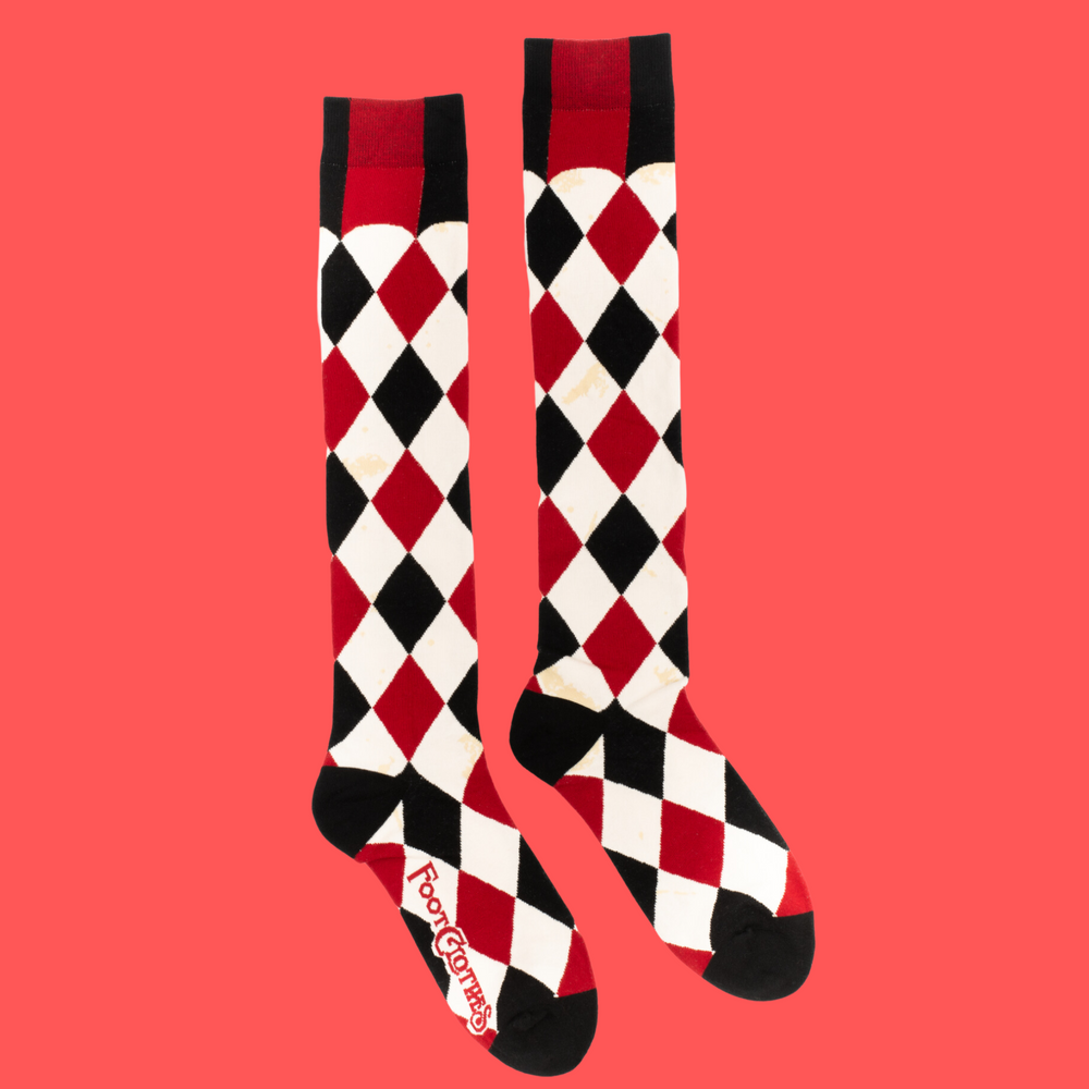 
                      
                        A pair of knee high socks with a harlequin pattern. Black, white and red. 
                      
                    