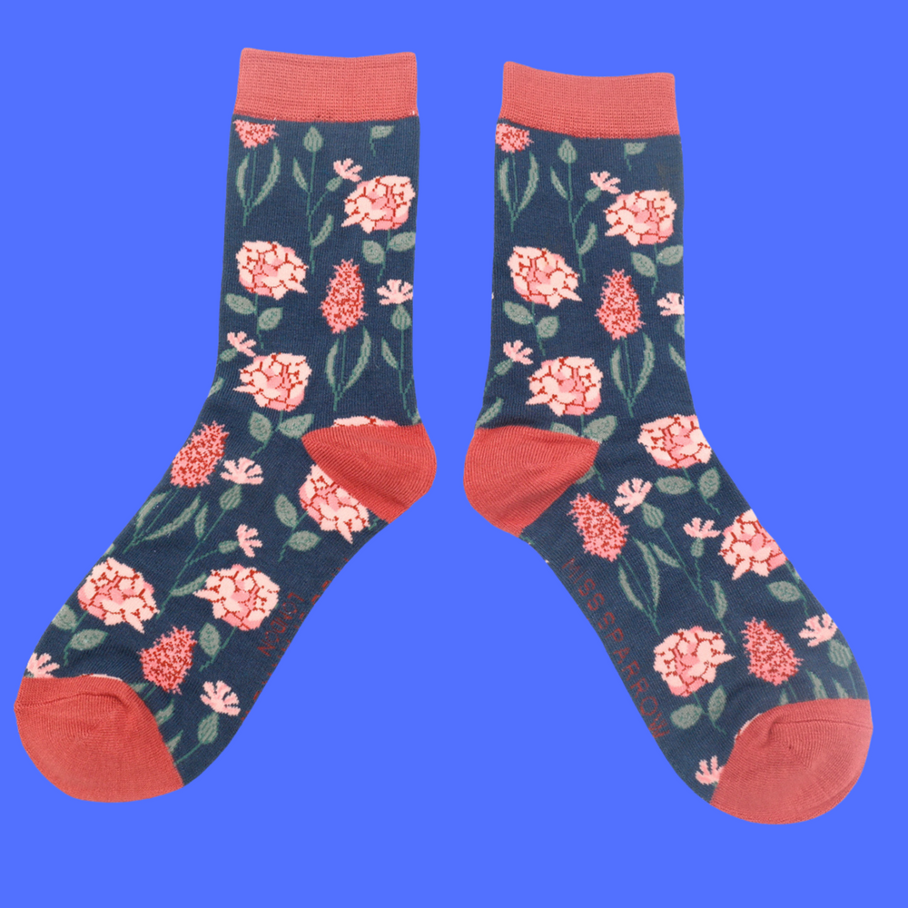 
                  
                    A pair of socks depicting British flowers and plants. Dark blue legs, red heel, cuff and toe.
                  
                