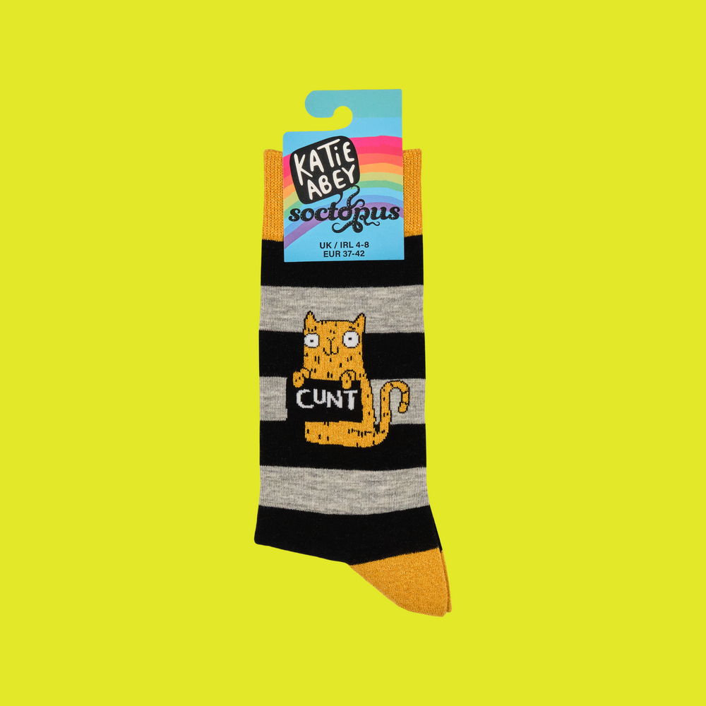 
                      
                        A pair of socks featuring a cute cat holding a sweary sign. Black and grey striped legs. Yellow heel, cuff and toe. 
                      
                    