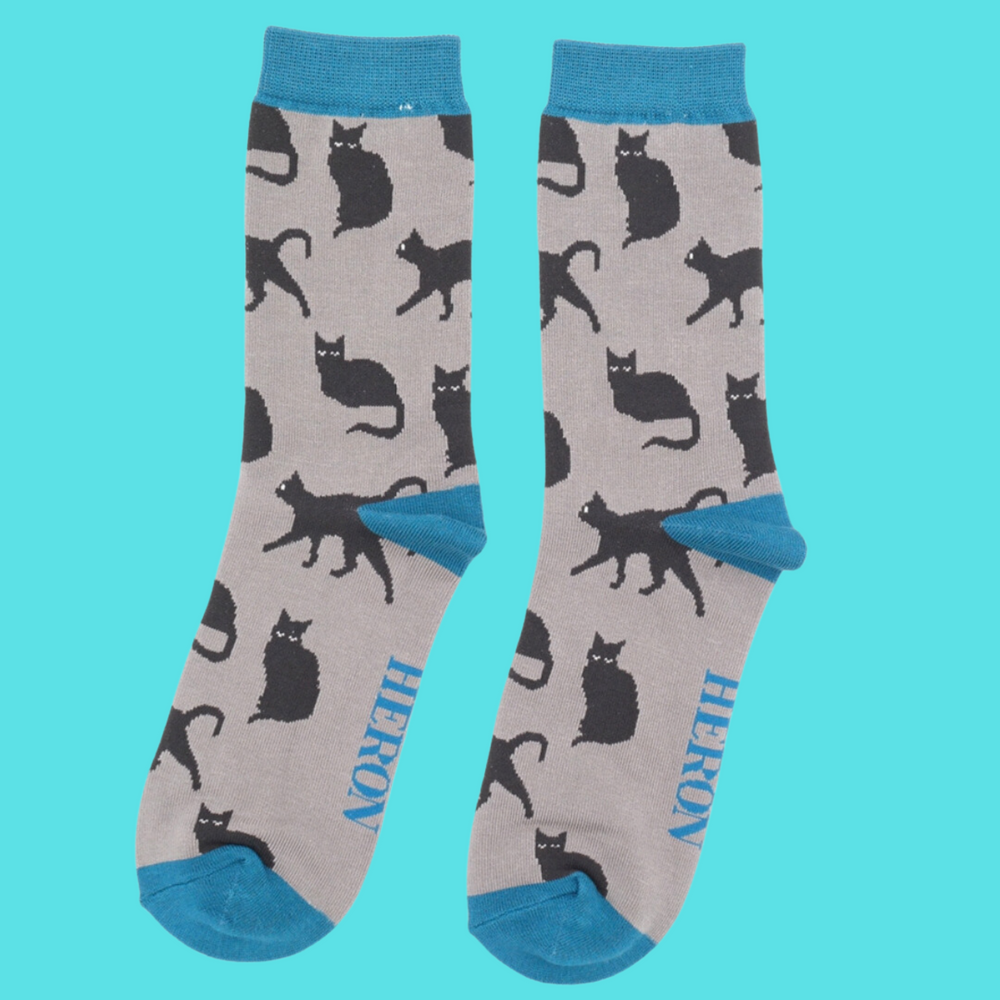 
                  
                    A pair of socks depicting cute black cats. Grey legs, blue toe, cuff and heel.
                  
                