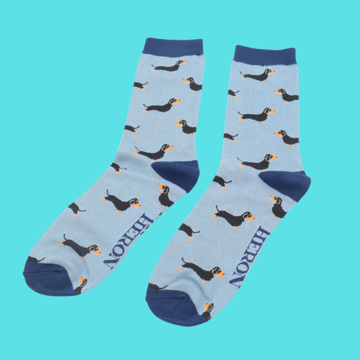 
                  
                    A pair of socks featuring a sausage dog pattern. Blue legs, dark blue cuffs, heel and toe.
                  
                