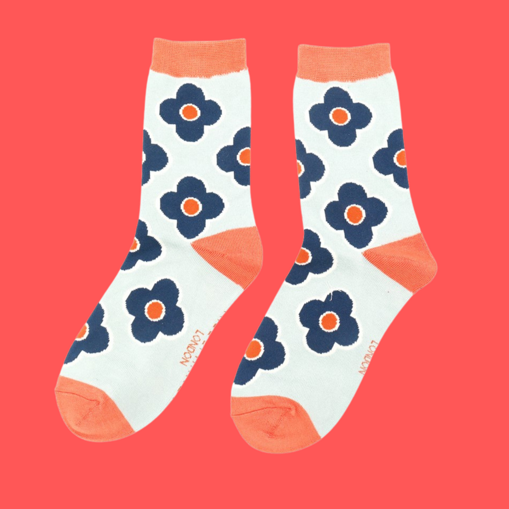 
                      
                        A pair of socks depicting a retro flower pattern. Cream legs, orange heel, toe and cuff.
                      
                    