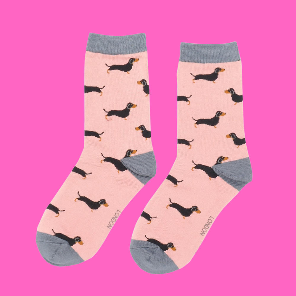 
                  
                    A pair of socks featuring a sausage dog pattern. Pink legs, grey cuffs, heel and toe.
                  
                