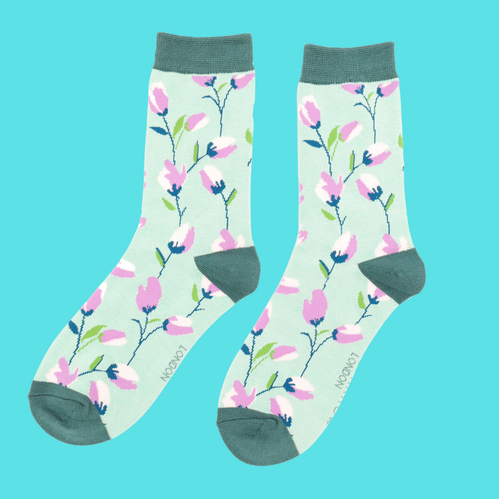 A pair of socks with a fun floral pattern. Green legs, green cuff, heel and toe.