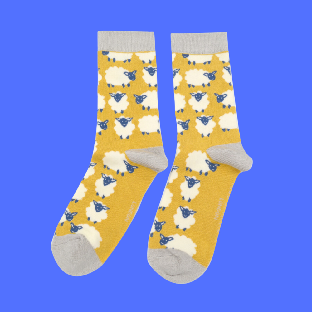 
                  
                    A pair of socks depicting happy sheep. Yellow legs, grey heel, toe and cuff.
                  
                