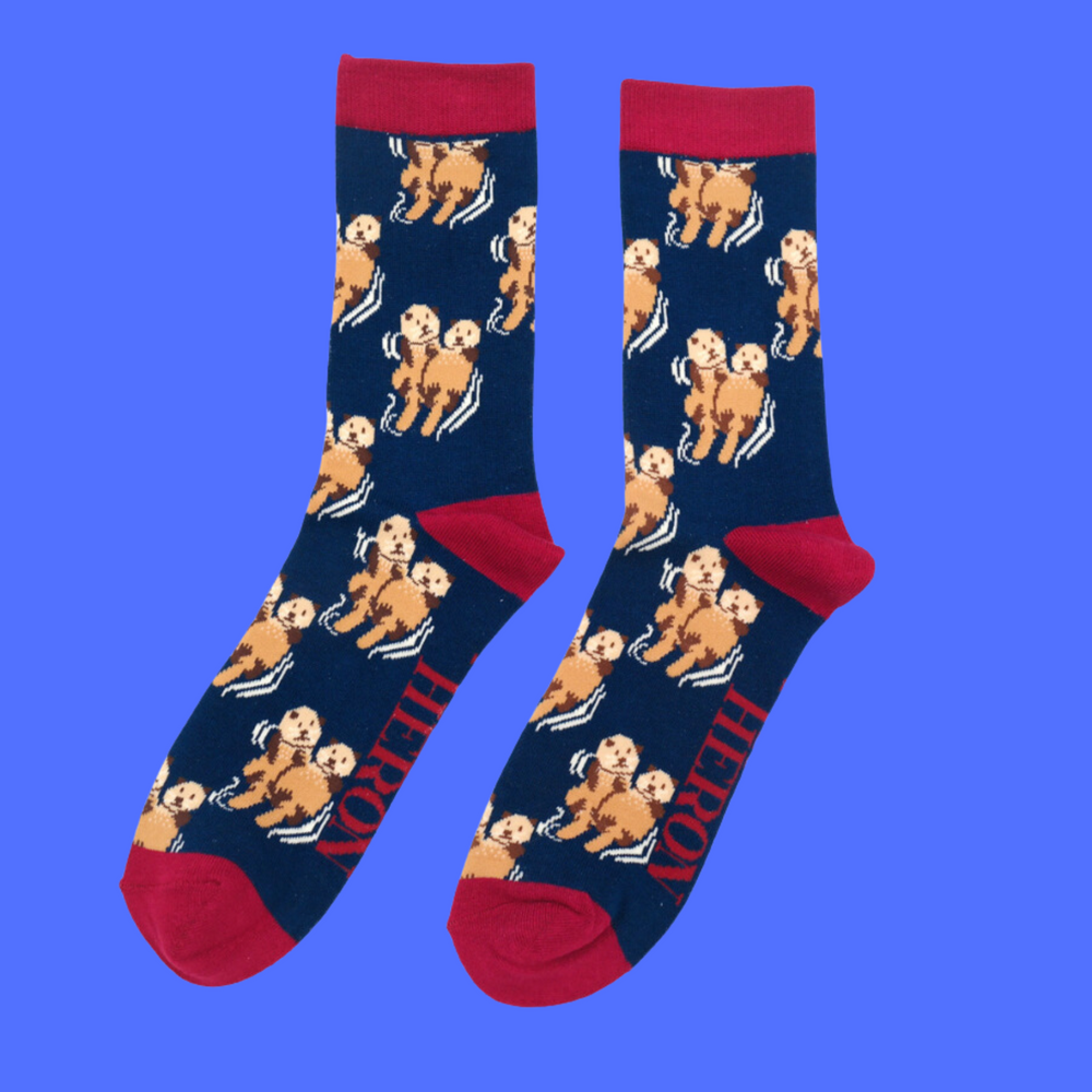 
                  
                    A pair of socks depicting otters holding hands. Blue legs, red heel, toe and cuff.
                  
                