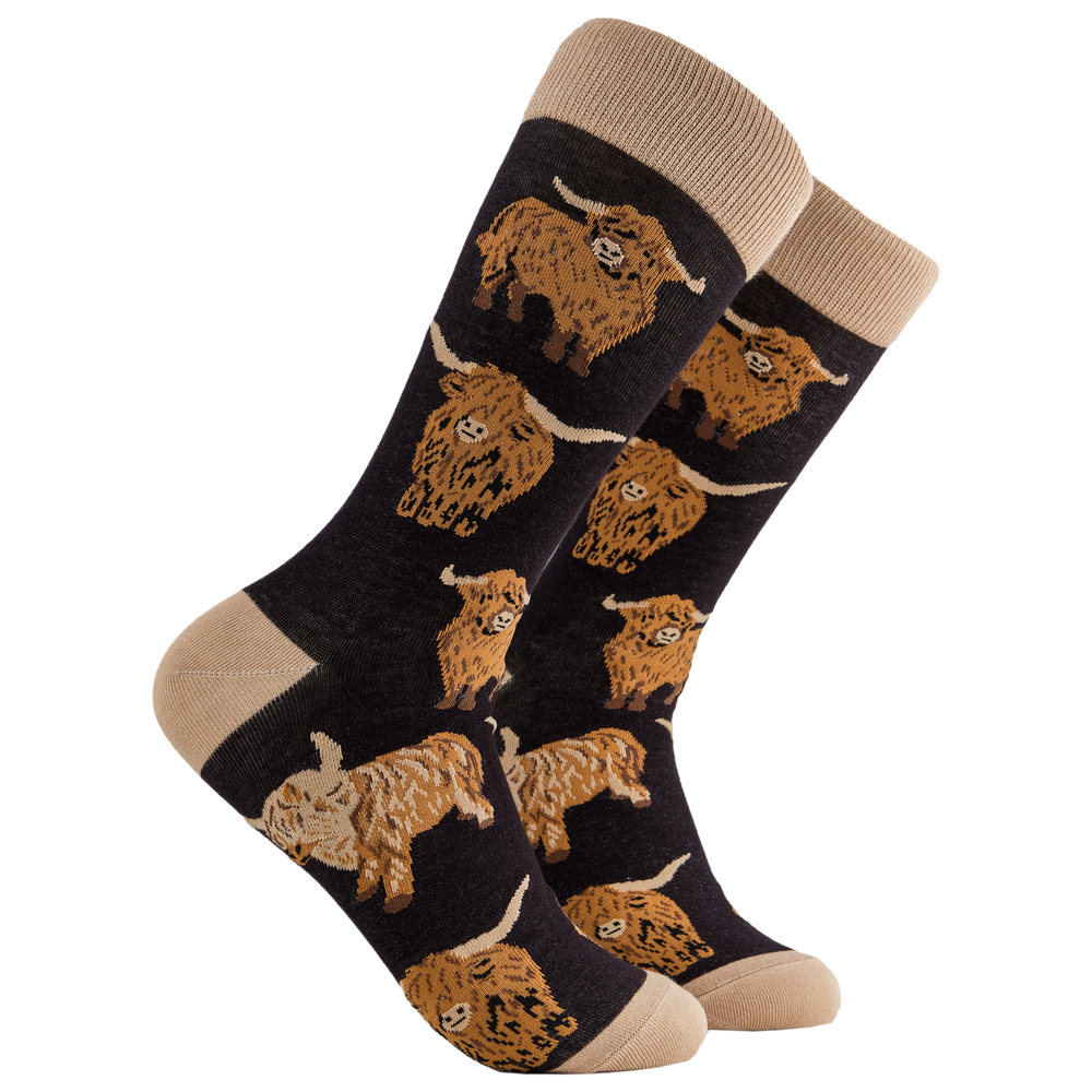 
                  
                    A pair of socks depicting highland cows. Black legs, cream cuff, heel and toe.
                  
                