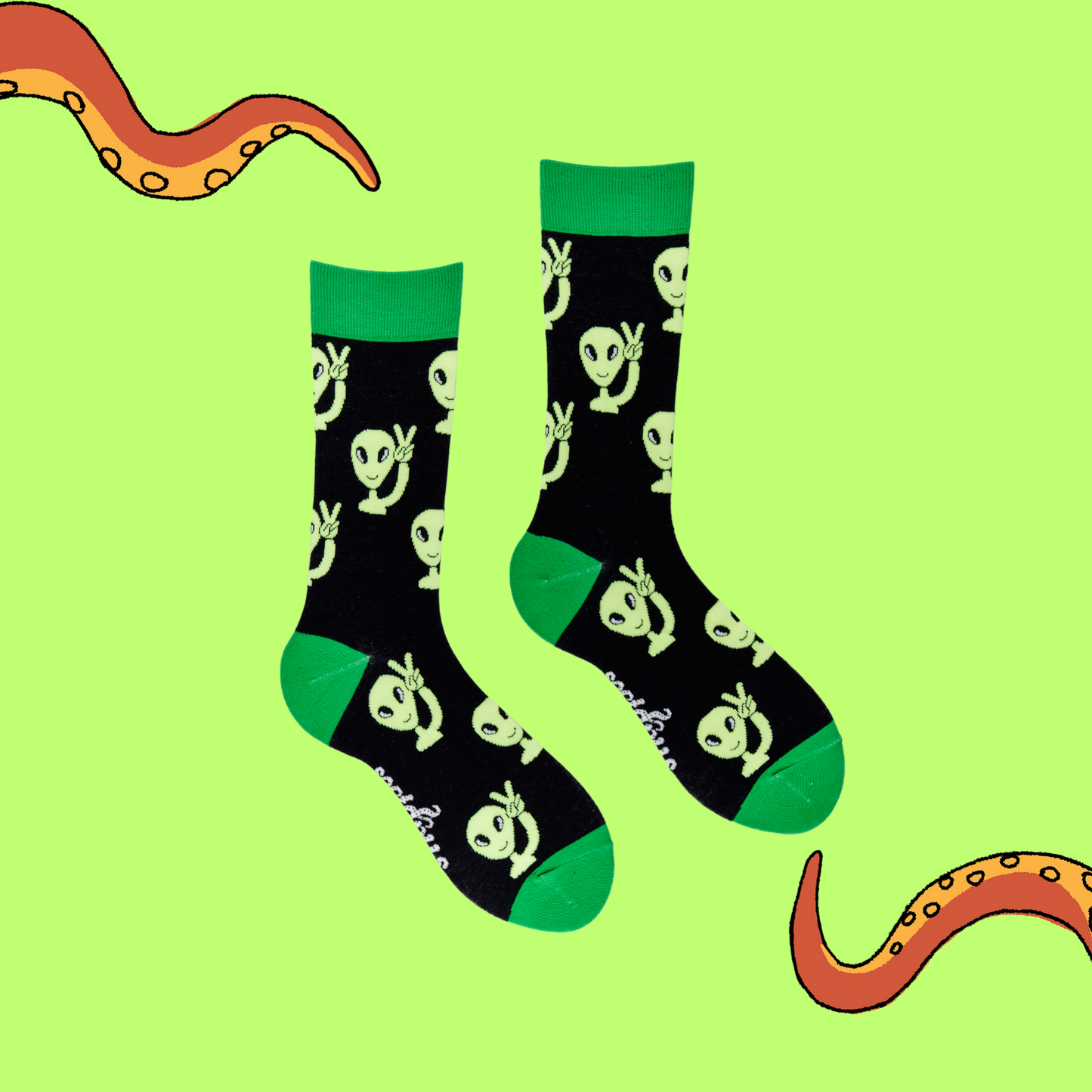 
                  
                    A pair of socks depicting peaceful aliens. Black legs, green cuff, heel and toe.
                  
                