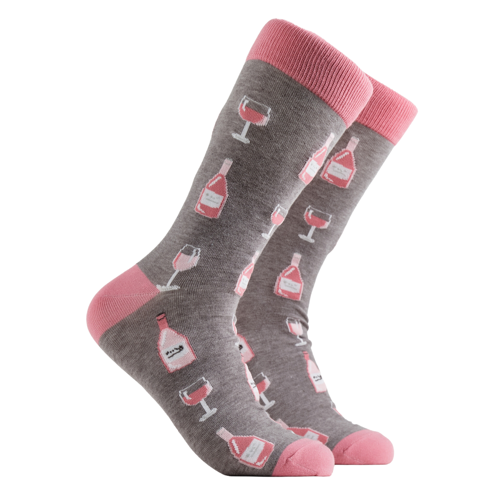 Wine Socks - Rosé O'clock. A pair of socks depicting Rose wine bottles and glasses. Grey legs, pink cuff, heel and toe.