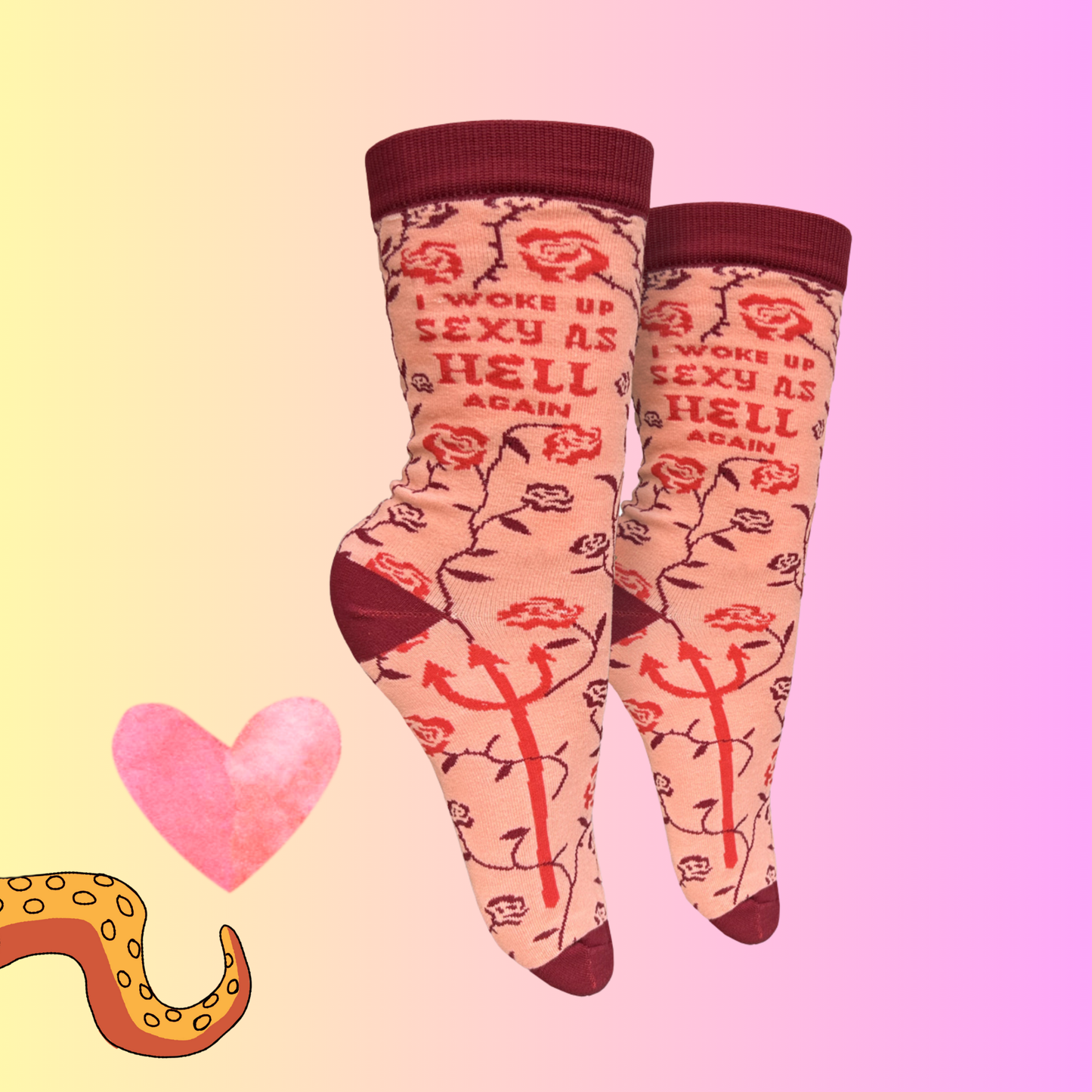 A pair of socks with a rose and devil motif. Pink legs, red cuff, heel, toe and cuff. 